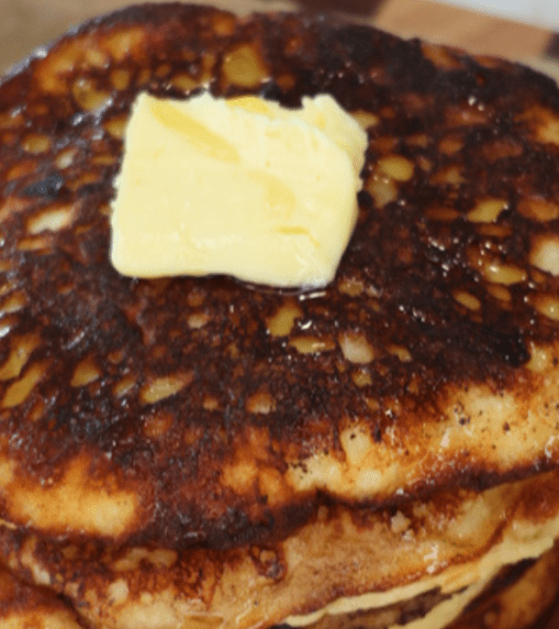 Fluffy gluten-free cottage cheese pancakes stacked on a plate and topped with fresh berries and a drizzle of maple syrup. These high-protein pancakes are made with cottage cheese, almond flour, eggs, and vanilla, and are naturally refined sugar-free, making them a healthy breakfast option.