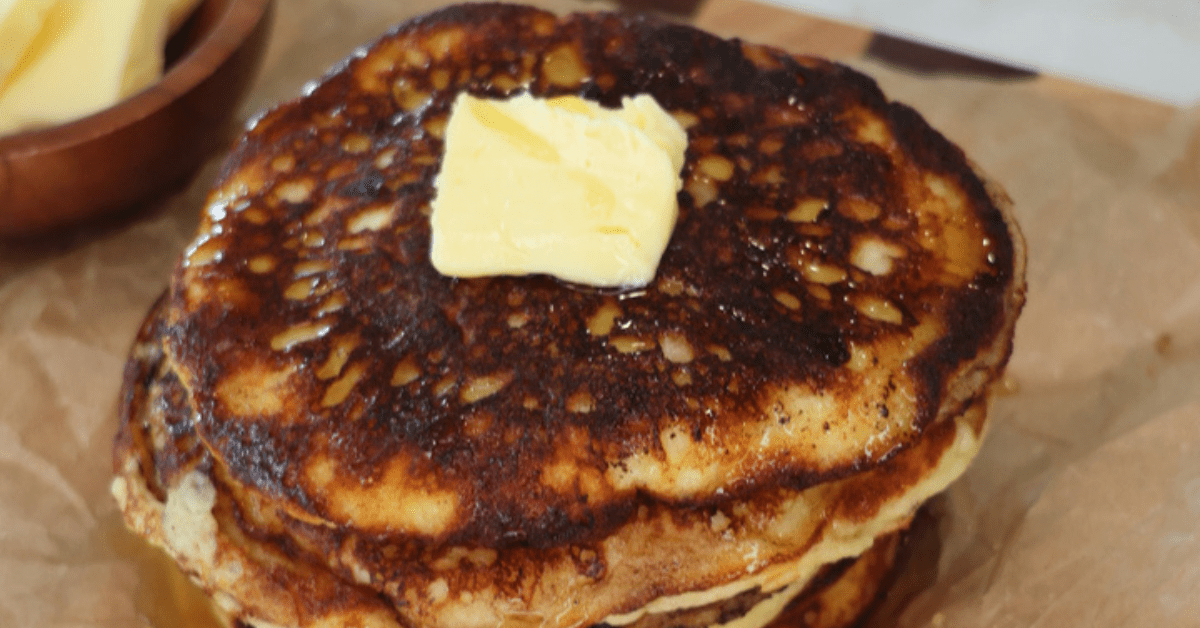 Fluffy gluten-free cottage cheese pancakes stacked on a plate and topped with fresh berries and a drizzle of maple syrup. These high-protein pancakes are made with cottage cheese, almond flour, eggs, and vanilla, and are naturally refined sugar-free, making them a healthy breakfast option.
