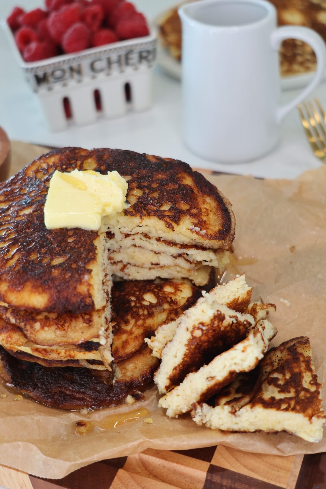 Fluffy gluten-free cottage cheese pancakes stacked on a plate and topped with fresh berries and a drizzle of maple syrup. These high-protein pancakes are made with cottage cheese, almond flour, eggs, and vanilla, and are naturally refined sugar-free, making them a healthy breakfast option.
