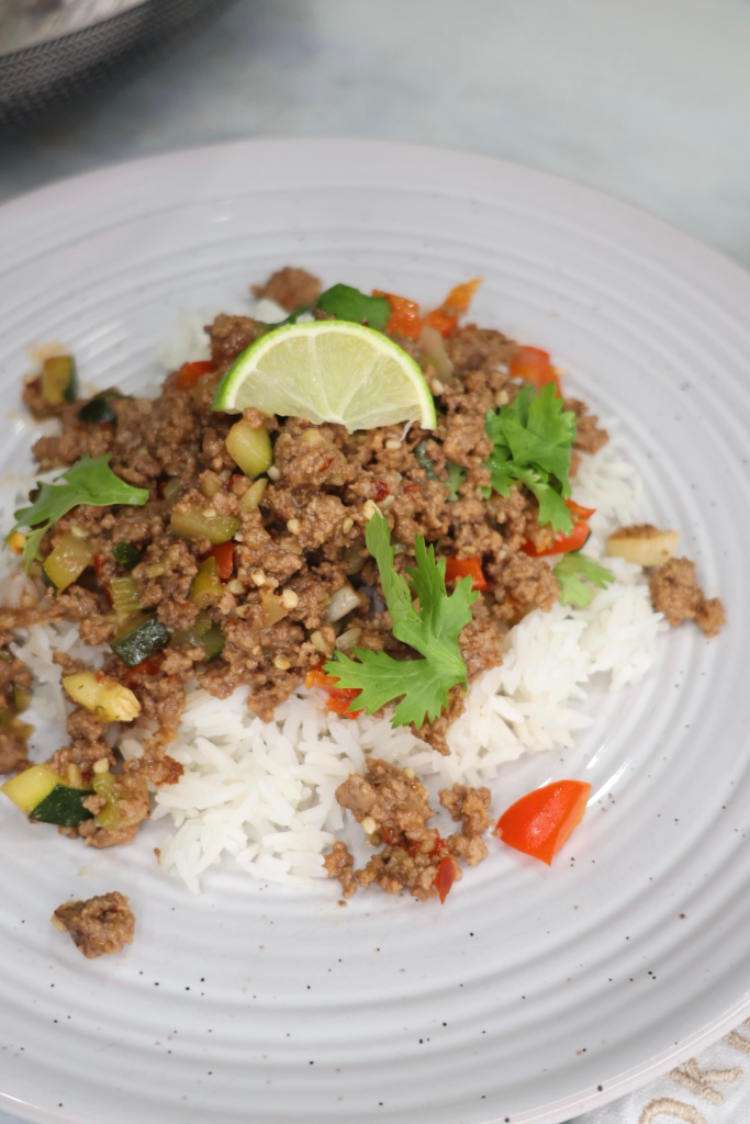 Chili Lime Beef Stir Fry served in a wok with fresh lime wedges and cilantro garnish