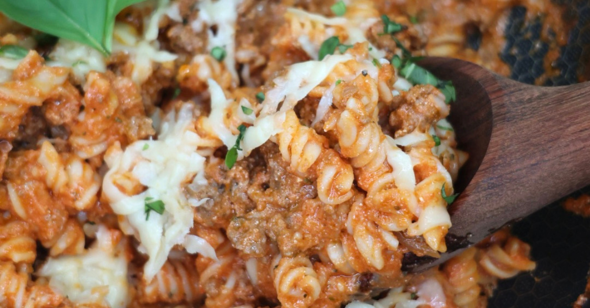 Creamy gluten-free fusilli pasta made with Taste Republic fresh pasta, coated in a blended tomato and cottage cheese sauce with grass-fed ground beef, parmesan, and basil in a skillet.