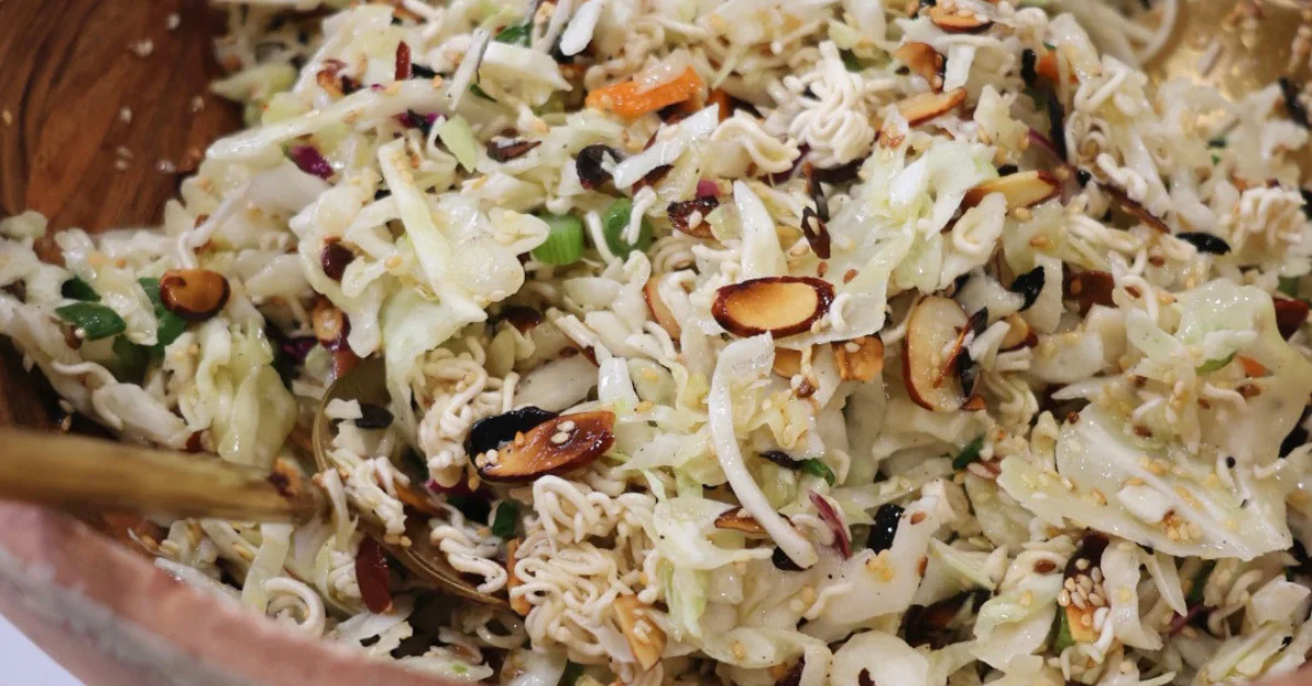 Bowl of Crunchy Ramen Cabbage Salad made with shredded cabbage, green onions, crunchy ramen noodles, toasted almonds, sesame seeds, and a sweet tangy dressing.