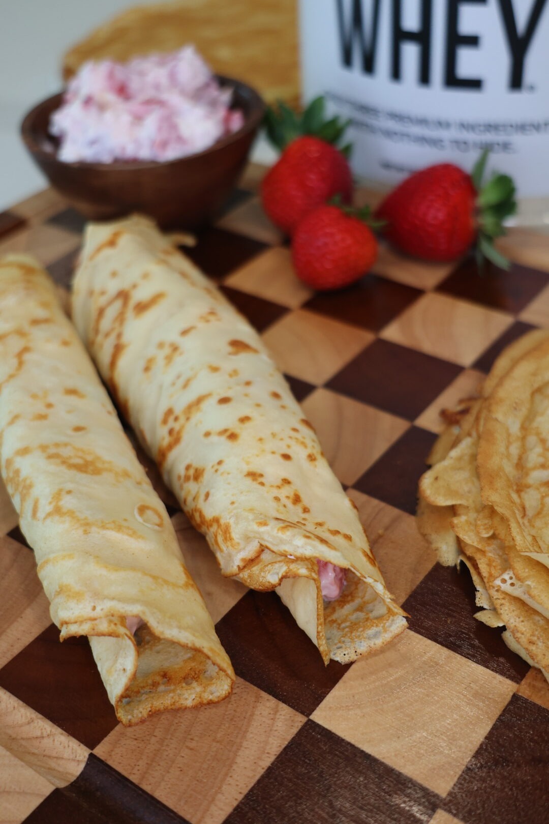 Greek Yogurt Strawberries and Cream Protein Crepes filled with creamy Greek yogurt filling and fresh strawberries on a white plate.