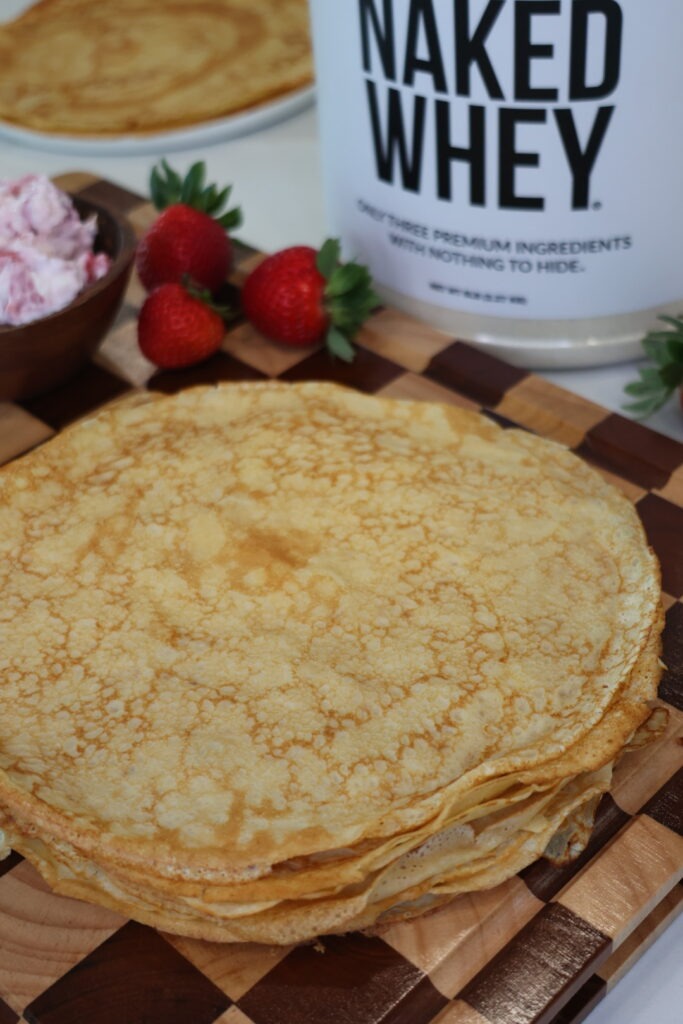 Greek Yogurt Strawberries and Cream Protein Crepes filled with creamy Greek yogurt filling and fresh strawberries on a white plate.